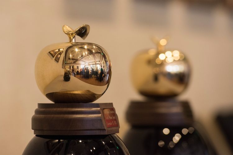 two awards in the shape of golden apples